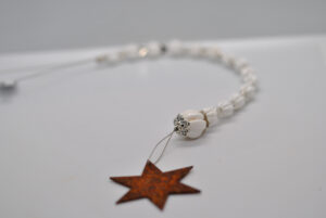 Fensterhänger mit weisser Muschel und rostigem Stern